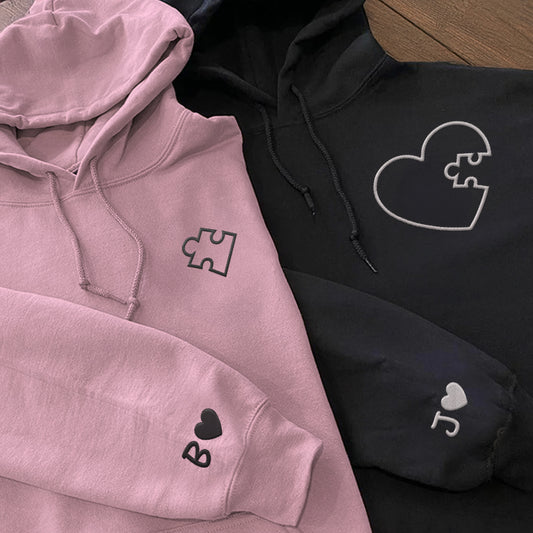 Pair of pink and black hoodies with embroidered puzzle heart design and custom initials