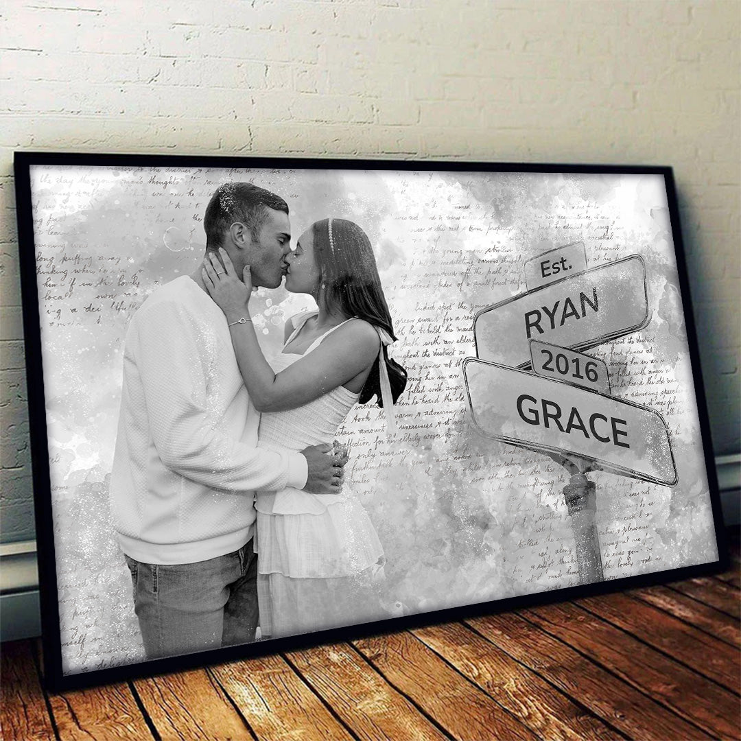 Couple in white kissing next to the street sign with their names and date